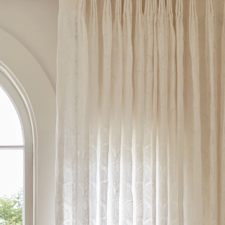 Tailored Pleat Drapery made in The Novogratz Feather Palm Embroidery in Vintage Lace over a sunny window in a living room