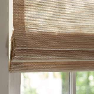 Sunlight peeks in through waterfall woven wood shades made from hemp-hued Grassweave material.