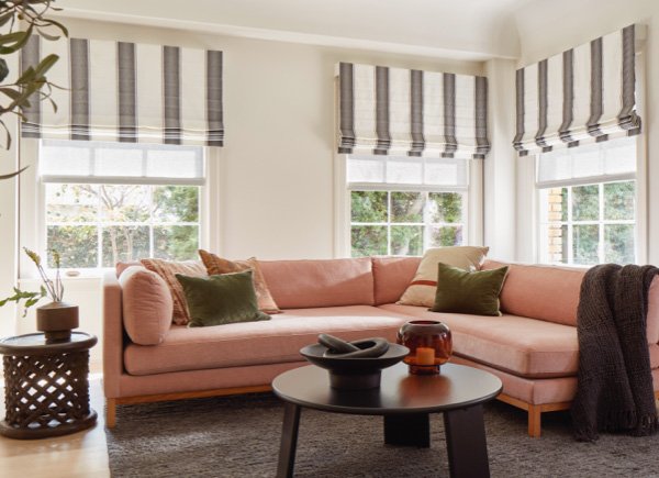 Erin Featherston Living Room featuring Cascade Roman Shades in material Nomad Stripe and color Graphite over Solar Shades
