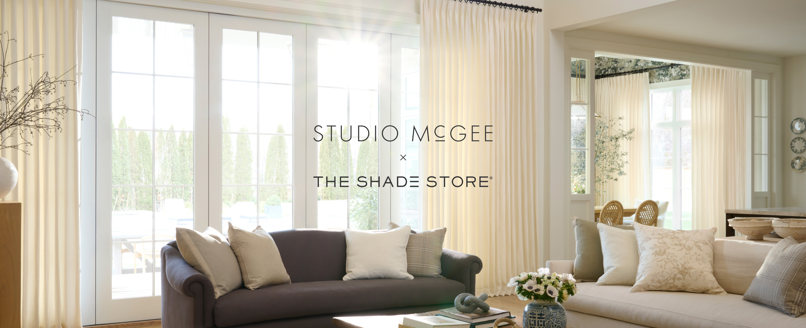 Image of a living room featuring Pinch Pleat Drapery of Studio McGee's Stonewash in Chalk with Studio McGee logo overlayed
