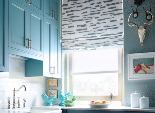Window with a Flat Roman Shade in Archer fabric with Lagoon colored stripes in a kitchen with blue cabinets and walls