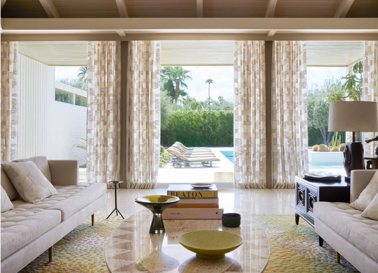 A bright, Mid-Century Modern living room featuring Ripple Fold Drapery in Martyn Lawrence Bullard Andreas in Parchment fabric.