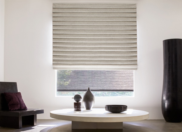 A window featuring pleated roman shades in wool blend fleece in a room with a low table, wood chair and large modern decor