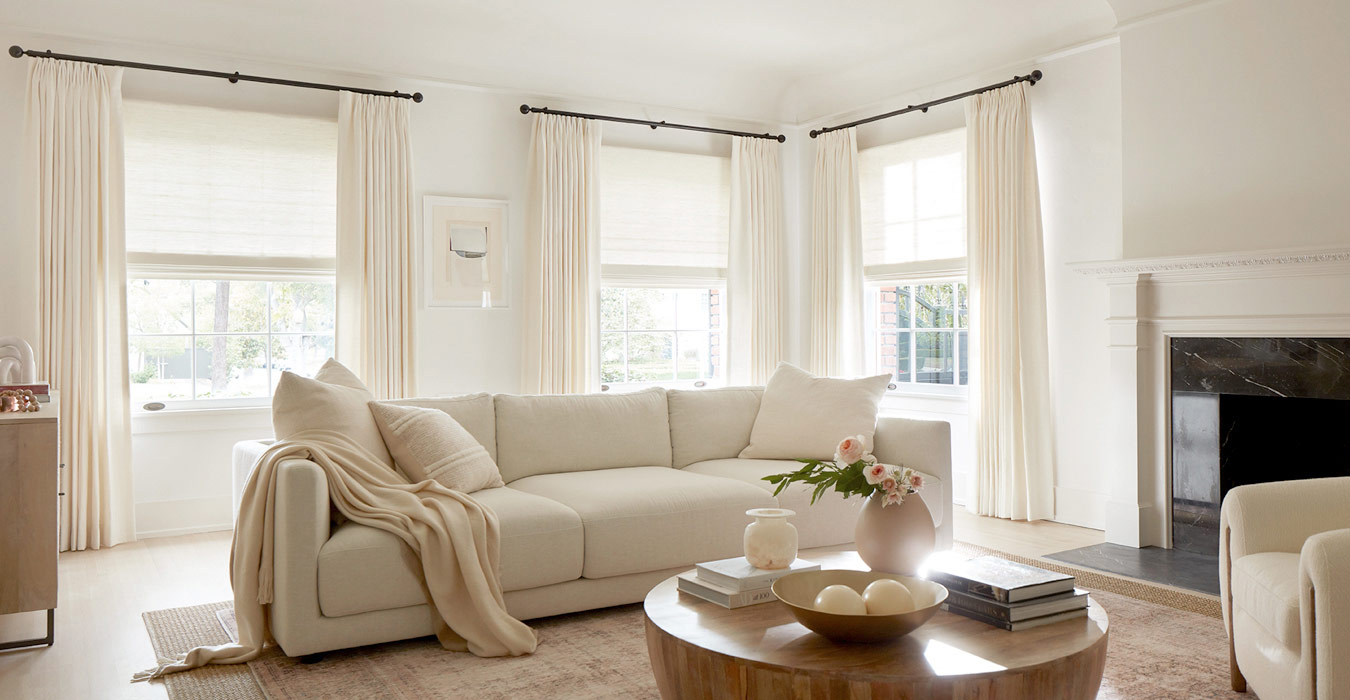 Multiple Windows featuring Pinch Pleat Drapery in neutral colors in Living Room with a large cream colored couch