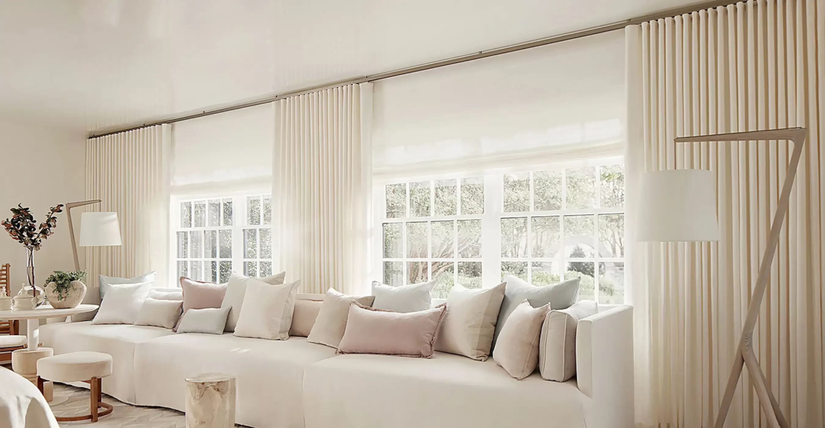 A bright sitting area has a warm ivory color scheme with matching Ripple Fold Drapery made of Heathered Linen in Ivory