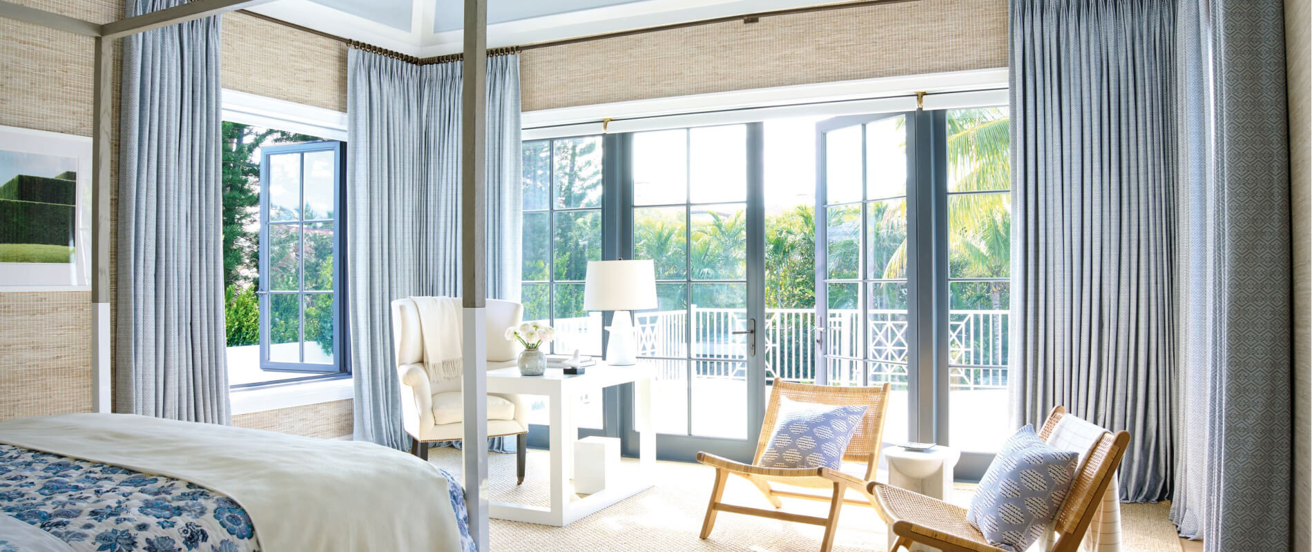 Spacious bedroom in blue and beige with open windows and French doors and coordinating Roller Shades and drapery.