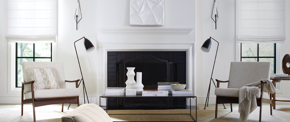 A bright white living room has a fireplace & tall windows with Flat Roman Shades of Victoria Hagan Sankaty Stripe in Sand
