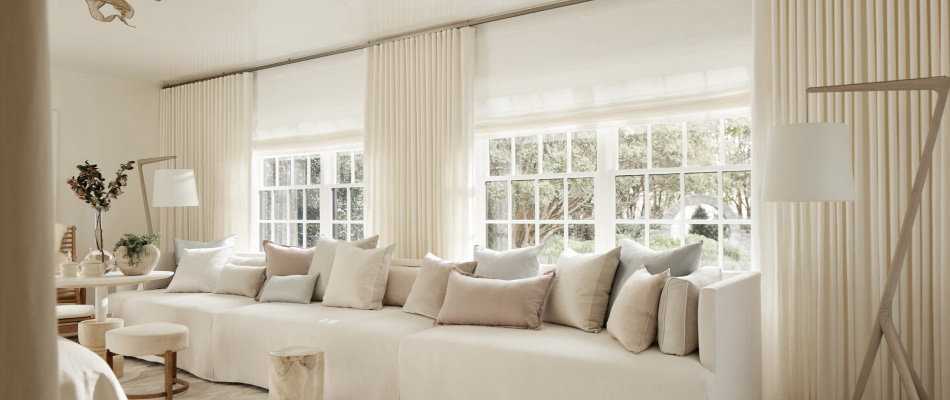 A bright sitting area has a warm ivory color scheme with matching Ripple Fold Drapery made of Heathered Linen in Ivory