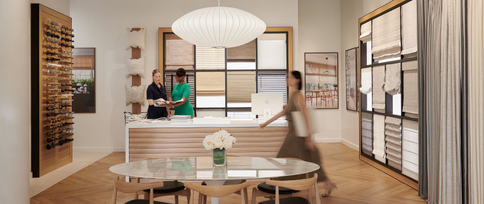 Three women in The Shade Store showroom explore swatch drawers and product displays to find the right window treatments