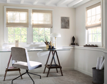 Cordless Woven Wood Shades made of Grassweave in Hemp hang in an office with a glass desk and upholstered chair