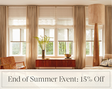 End of Summer Event: 15% Off written in black text over an image of layered Shades & Drapery in a living room with wood decor