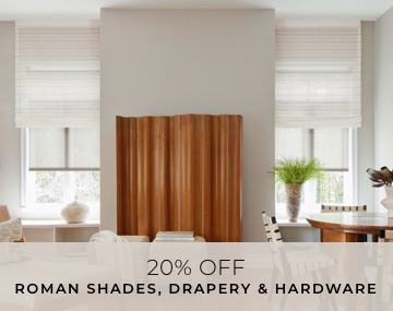 Tall windows with motorized Roman and Roller Shades in a family with wood furniture and artwork with overlaid sales messaging