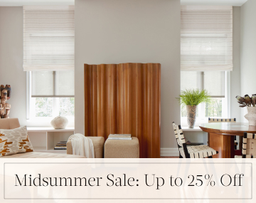 Motorized Roman and Roller Shades hang in a family room with wood decor with overlaid text, Midsummer Sale: Up to 25% Off