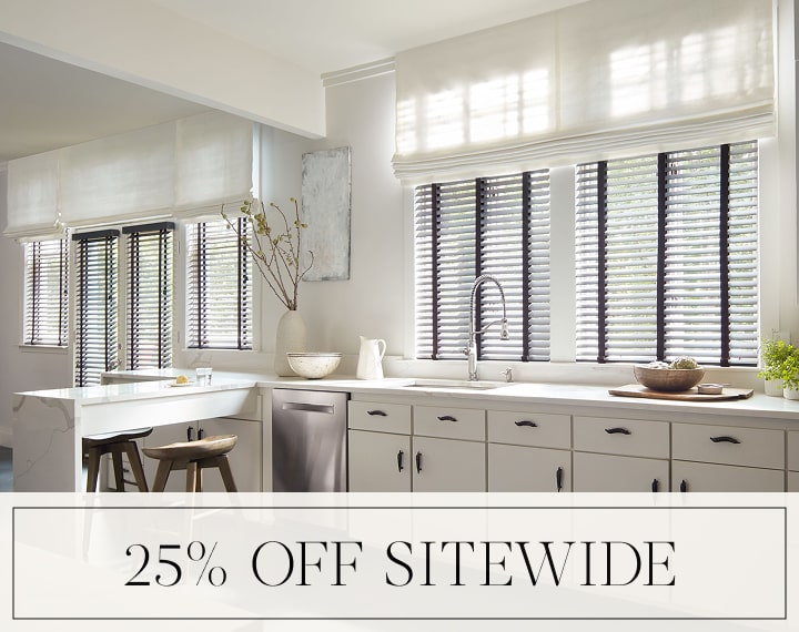 25% Off Sitewide in black text over an image of a kitchen with Flat Roman Shades and Wood Blinds.