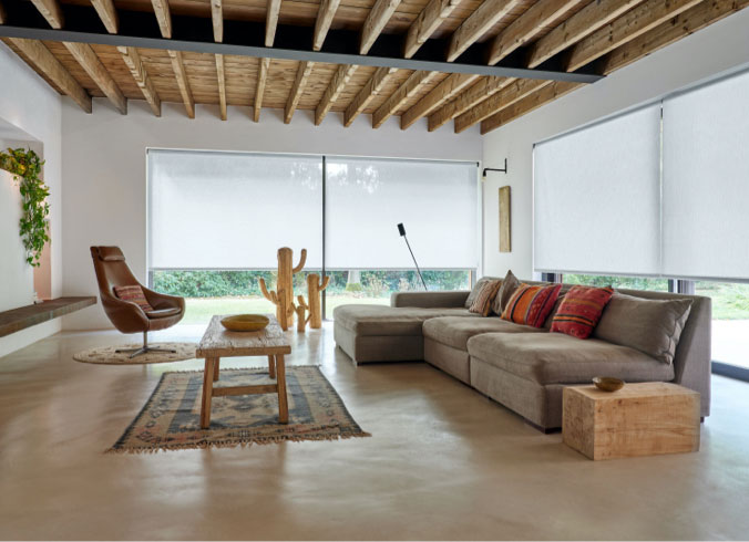 Living room with rustic decor with large windows featuring Roller Shades in 3 percent Thermo Material in the color Cloud