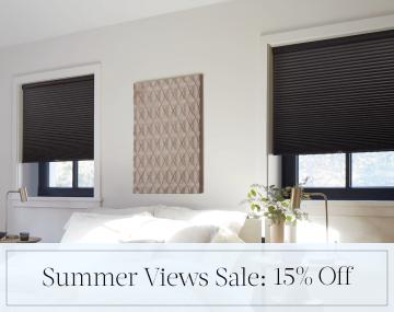 Cellular Shades in Midnight hang in a contemporary bedroom with overlaid sales messaging for Summer Views Sale: 15% Off