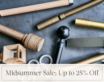 Pieces of drapery hardware in metal & wood finishes lay on a stone table with overlaid text, Midsummer Sale: Up to 25% off