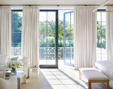 Tailored Pleat Drapery made of Petal in Pearl hang floor to ceiling over patio doors in a luxe bedroom with neutral decor