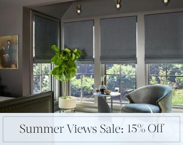 Flat Roman Shades of Wool Blend, Charcoal cover bedroom windows with overlaid sales messaging for Summer Views Sale: 15% Off