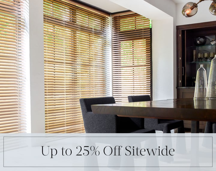 Up to 25% Off Sitewide in black text over an image of dining room windows with Champagne Metal Blinds.