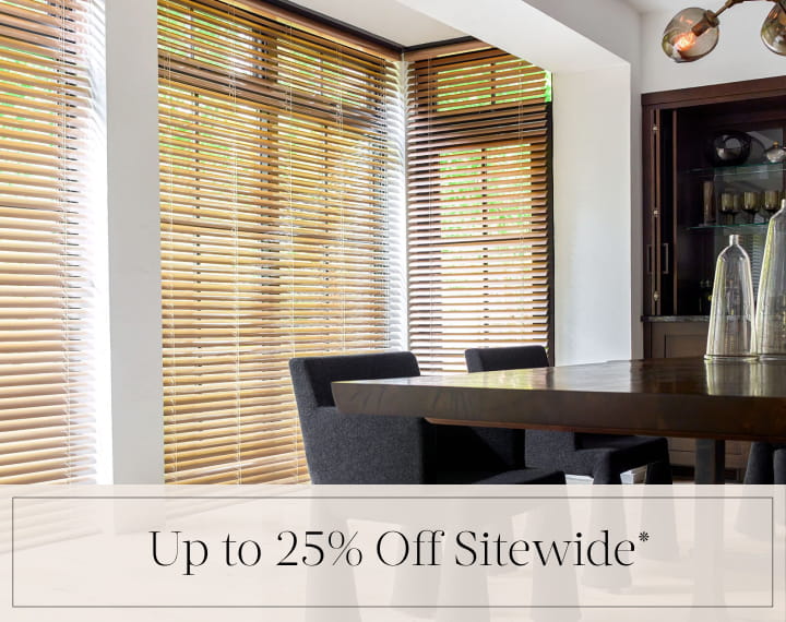 Up to 25% Off Sitewide in black text over an image of dining room windows with Champagne Metal Blinds.