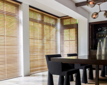 2 Inch Champagne Metal Blinds hung over floor to ceiling windows in a dining room with a large table