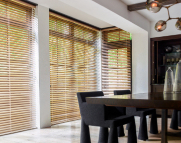 2 Inch Champagne Metal Blinds cover tall windows in a modern dining room with a large black table with matching chairs