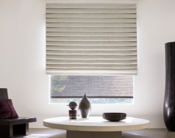 Pleated Roman Shade made of Wool Blend in Fleece adds lush folds to a modern room with a white table and large black vase