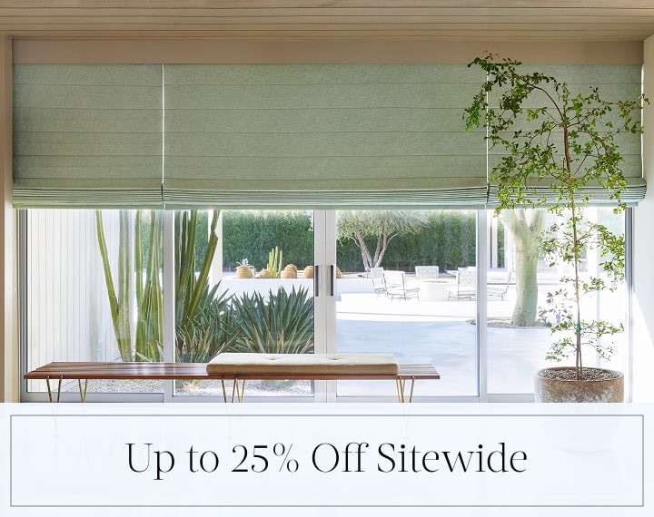 Up to 25% Off Sitewide in black text over an image of living room windows with sage green Roman Shades.