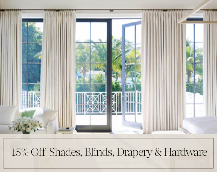 15% Off Shades, Blinds, Drapery & Hardware in black text over an image of Tailored Pleat Drapery on patio doors in a bedroom