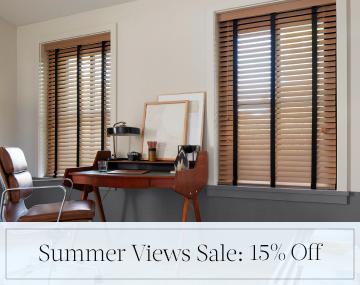 Oak Wood Blinds hang in an office with a wood desk & leather chair with sales messaging for Summer Views Sale: 15% Off