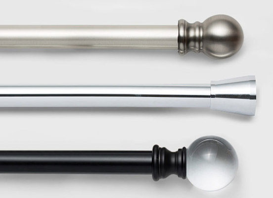 Three drapery hardware options in various Carnegie finishes laid out on a white table top