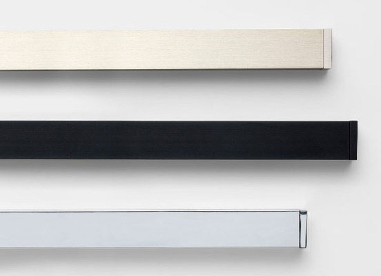 Three drapery hardware options in various Lincoln finishes laid out on a white table top
